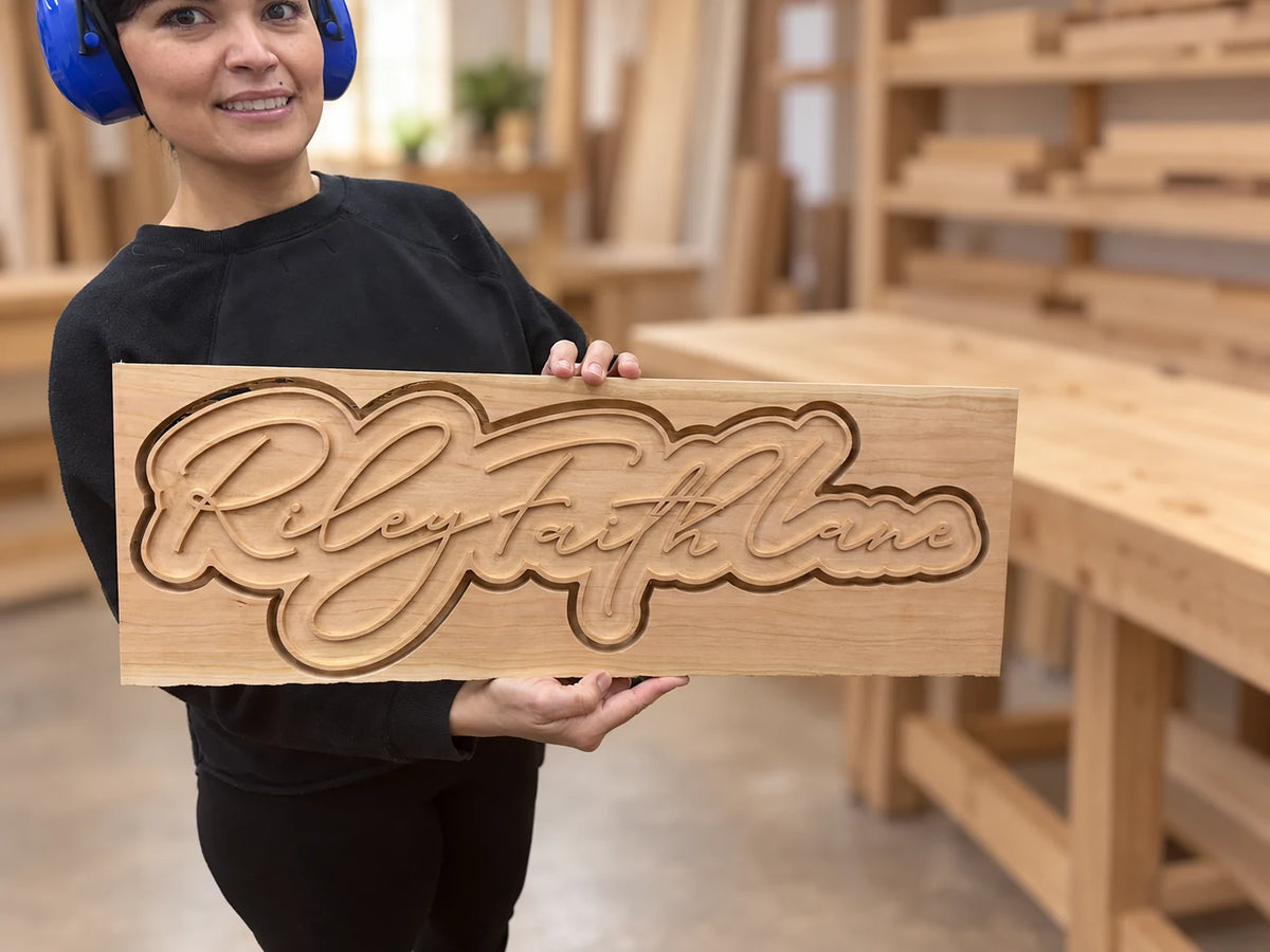 Maria holding a custom relief-carved wooden sign
