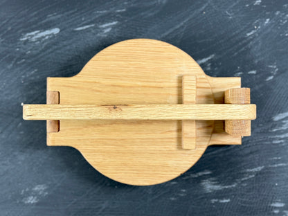 White oak tortilla press showing its brass rod hinges